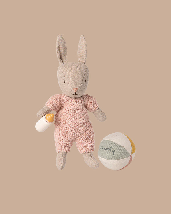 The PRE-ORDER: Rabbit Set, Micro - Sand - Rose (ships early November) features a soft fabric bunny in a pink knitted outfit holding a baby bottle, paired with a pastel "milk" ball—perfectly charming against a beige background.