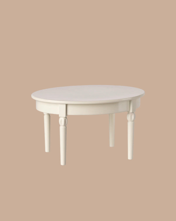 The PRE-ORDER: Vintage Dining Table, Mouse - Off White features a round white wooden design with detailed legs, showcased against a plain beige background. Estimated ship date is early October.
