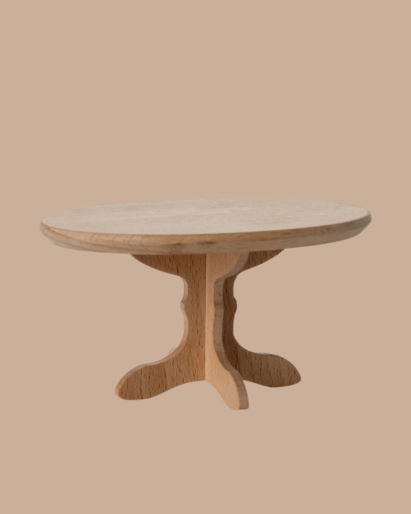 The PRE-ORDER: Oval Dining Table, Mouse - Nature features a light wood finish, single pedestal base with two curved supports, and an elegant oval shape. Perfect for a cosy dinner party. Estimated ship date: Early October.