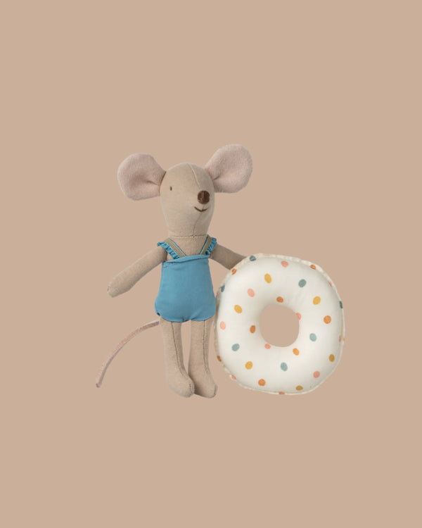 The Maileg Beach Mouse With Float, Little Sister - Multi Dot features a little sister mouse in a blue swimsuit beside a plush multi-dot donut float, all set against a plain beige background.