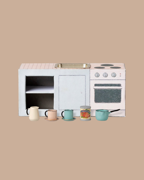 A PRE-ORDER: Maileg Kitchen Counter, Mouse (Approx. Ship Date: November), with stove, sink, oven, and counter sits on a beige background. In front are a white pitcher, pastel cups with saucers, and a toy can labeled "tomato soup.