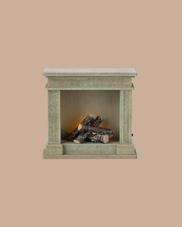 PRE-ORDER: Fireplace, Miniature – Dusty Green (ships early October), features a small rectangular shape with vintage finish and artificial logs; perfect for adding charm to any miniature home. Set against a plain beige background.