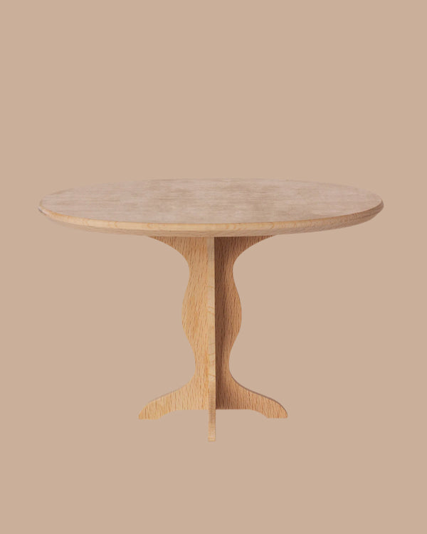 The PRE-ORDER: Oval Table, Mini - Nature (ships early October) features a light wood finish, fine craftsmanship, and a sculpted central pedestal base, presented against a plain beige background.