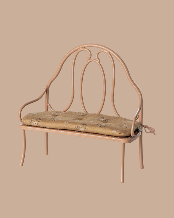The PRE-ORDER: Vintage Bench, Mini - Dark Powder is a small, vintage-style bench with ornate backrest and curved arms, featuring a comfy beige floral cushion—ideal for bunnies or rabbits—and set against a plain beige background. Estimated ship: Early October.