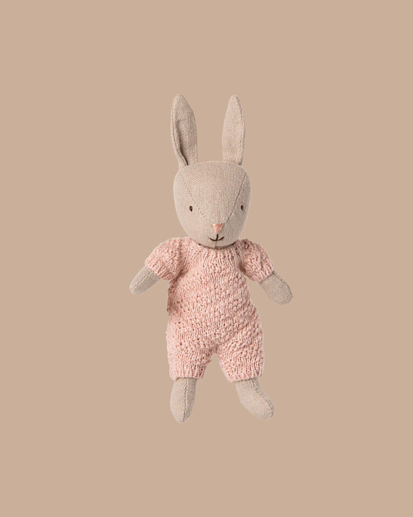 The PRE-ORDER Rabbit Micro - Sand in a rose knitted suit (ships early October) sits upright on a plain beige background—ideal for House of Miniature dollhouse displays or pairing with Maileg accessories.