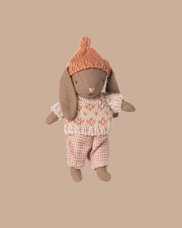 PRE-ORDER: Winter Bunny, Micro - Brown - Rose features a soft bunny in a knitted orange hat, cream and orange sweater, and pink patterned pants—ideal as Maileg accessories or for a miniature dollhouse. Ships early November.