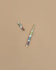 The Book Club Pen, featuring a gold cap and a vibrant patterned design, rests on a solid light brown background. Its cap is removed and positioned at the upper left of the pen.