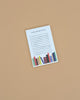 The "To Do, Or Not To Do Notepad" features lined spaces for your tasks and colorful illustrated books at the bottom, all on a beige background. This charming tear-off notepad is perfect for organizing your to-do list with style.