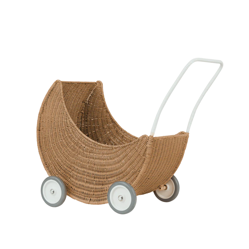 The Olli Ella Moon Strolley is a crescent moon-shaped toy stroller made from natural rattan, featuring four white wheels and a white handle—an adorable push-along for little ones.