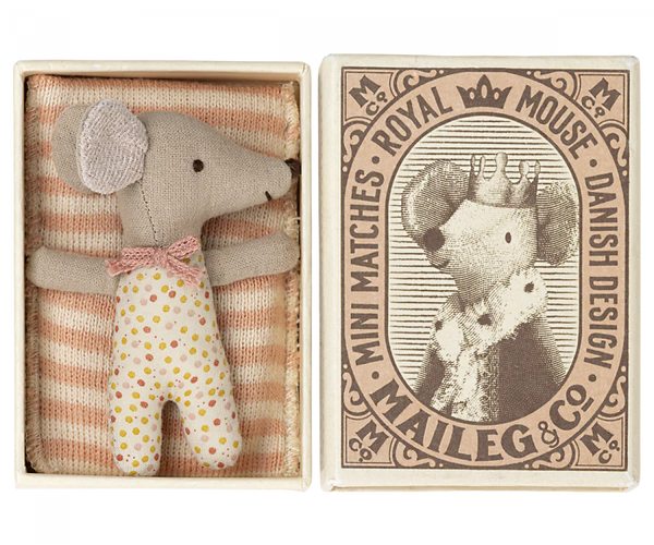 a small mouse doll inside a match box, with a blanket.