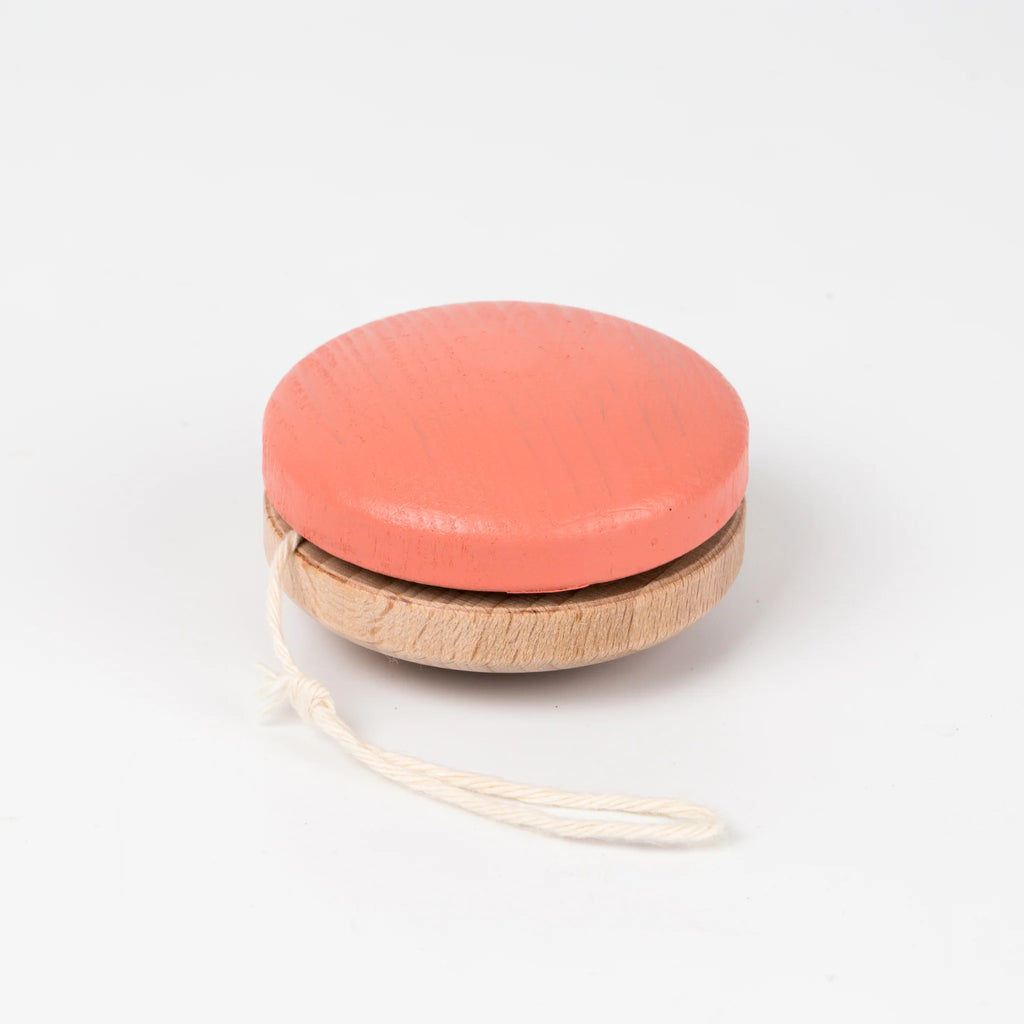 A red painted Wooden Yoyo made of beech wood with a white string, placed on a plain white background.