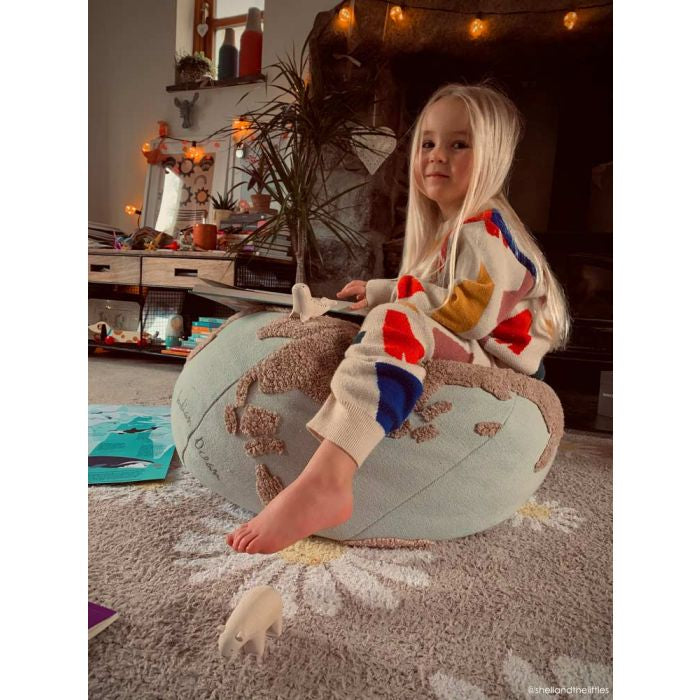 Kid sitting on world shaped pouf