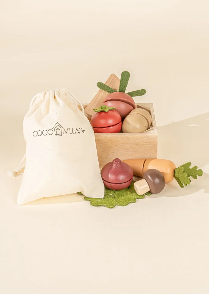 Sliceable wooden vegetable toys in a wooden crate with a wooden knife.