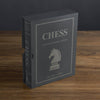 A gray box labeled "Chess Vintage Bookshelf Edition" with a knight chess piece graphic sits upright on wood. This collectible strategy game is for ages 9+ and supports up to 8 players.