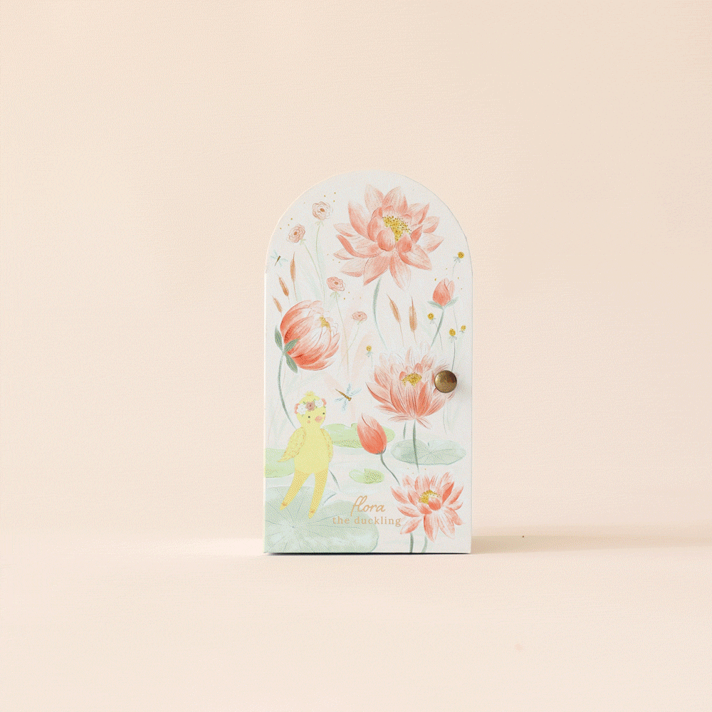 The illustrated Cuddle + Kind Tiny Flora the Duckling (Mauve) book showcases a floral cover with a small figure, revealing whimsical artwork of cartoonish ducks, landscapes, and imaginative scenes. Its pastel hues and elegant design capture the charm of handmade dolls.