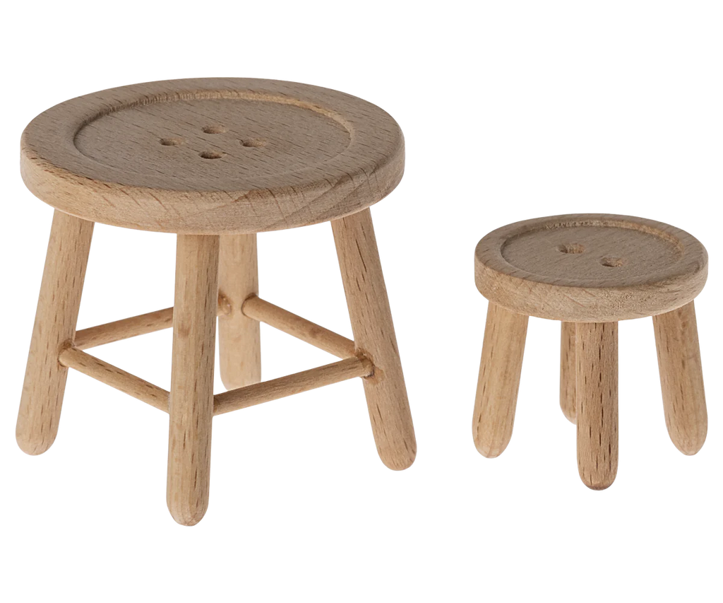Part of the Maileg Living Room Set, two wooden stools resembling buttons, one larger than the other, accompany a Maileg Floor Lamp. The stools feature round seats with button impressions and three legs in natural wood finish against a white background.