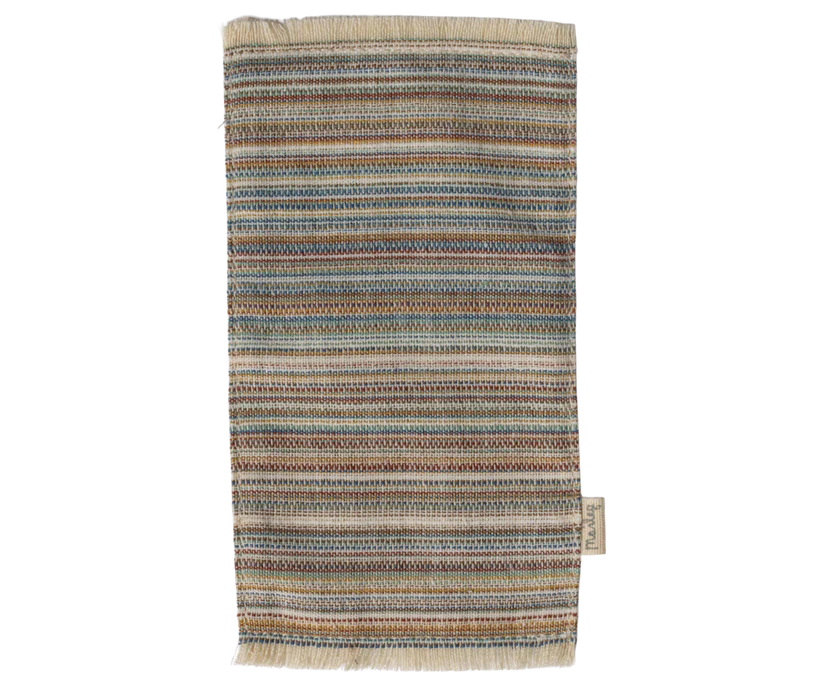 A multi-colored kitchen towel with horizontal stripes in blue, red, green, orange, and beige complements any kitchen featuring Maileg Living Room Set designs. The woven towel has a textured look, fringed edges, and a small side label.