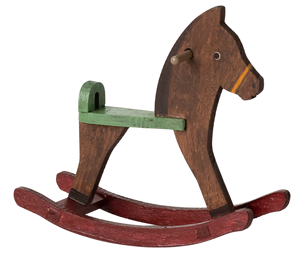 The Maileg Mouse Rocking Horse, available for shipping in a week, features a simple design with a brown body and green seat on red rockers. Its basic shape, peg tail, and minimalistic face invite children and imaginary mice to charming adventures in whimsical play scenes.
