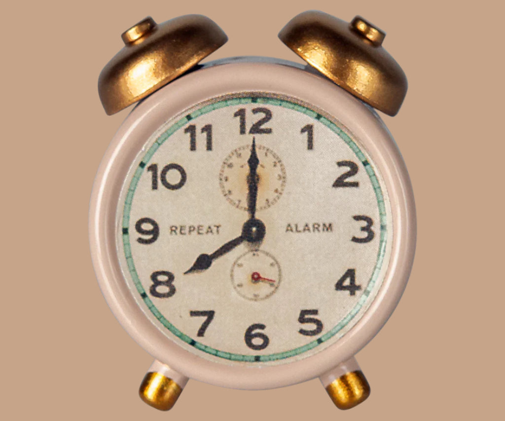 A vintage white and gold analog alarm clock with twin bells and black numbers on its face, set against a beige background—pairs perfectly with your Maileg Moms Afternoon Tea Set display.