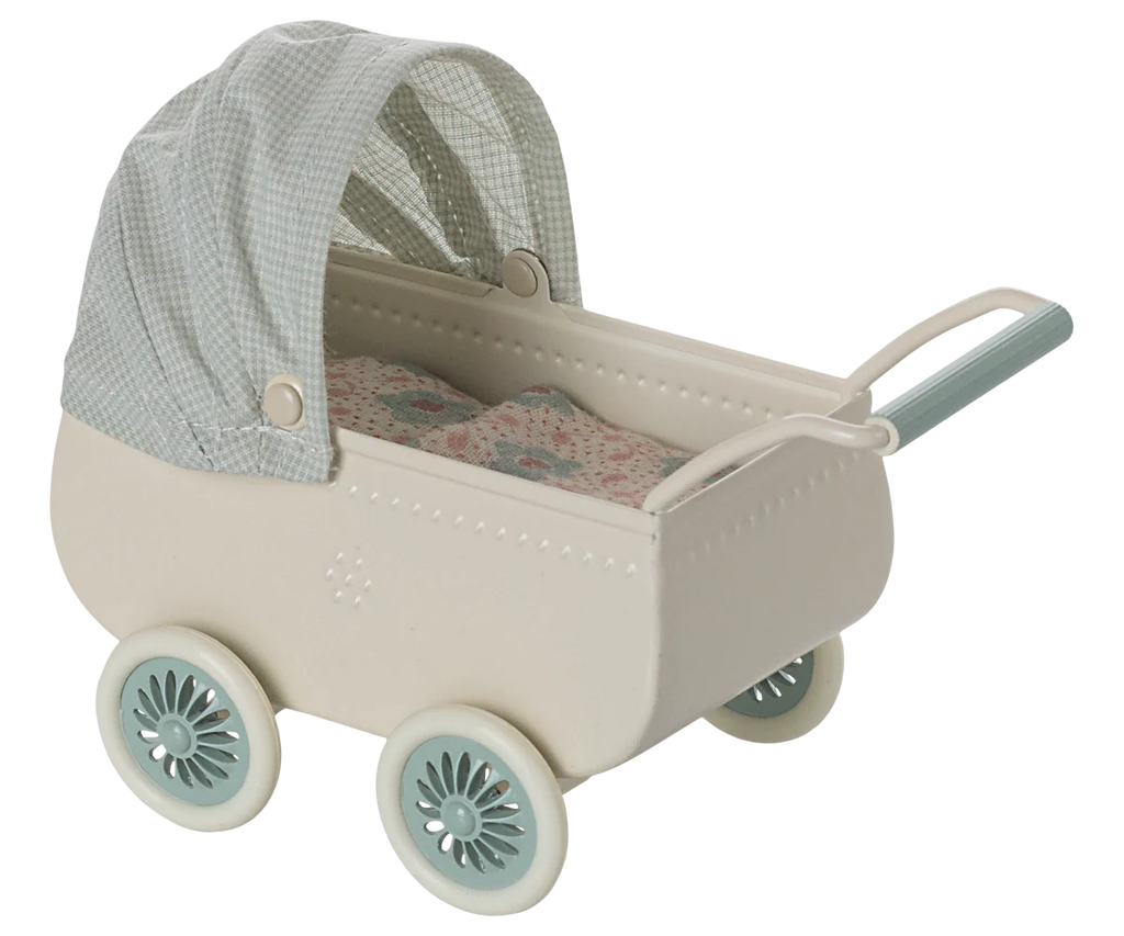 The Maileg Pram With Baby Mouse – Mint has a vintage style with a cream body, four mint green wheels, a matching handle, and a blue gingham canopy. Inside is a patterned mattress, adding extra charm to this adorable toy.