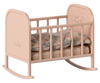 The Maileg Nursery Set is a delightful addition for any doll house, featuring a charming small pink toy cradle with floral engravings. It comes complete with a patterned pillow and mattress, perfect for Maileg fans.