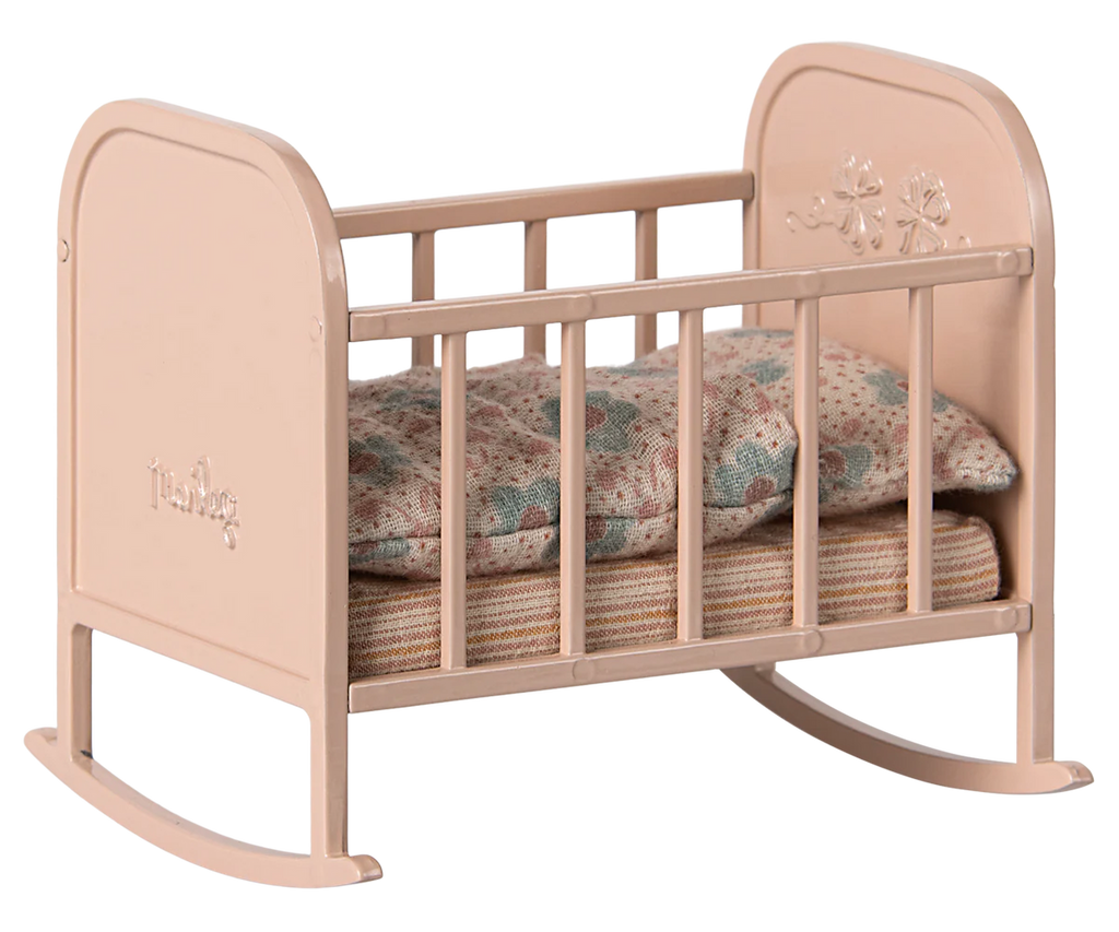 The Maileg Nursery Set is a delightful addition for any doll house, featuring a charming small pink toy cradle with floral engravings. It comes complete with a patterned pillow and mattress, perfect for Maileg fans.
