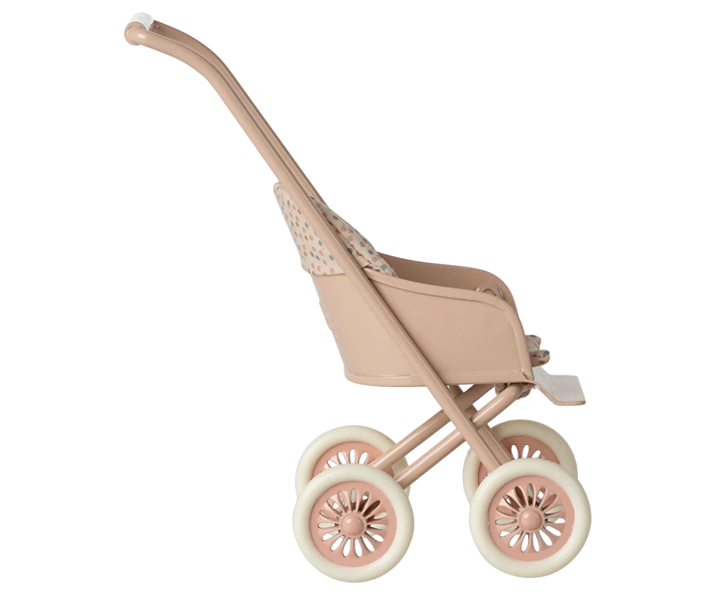 A Maileg Stroller, Micro - Powder in tan and beige plastic with four wheels, shown from the side against a softly blurred pastel-striped background.