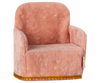 The Maileg Nursery Set's small pink plush chair, featuring a golden fringe trim and a cozy rounded back with armrests, pairs perfectly with the charming Miniature Floor Lamp for a relaxing ambiance.