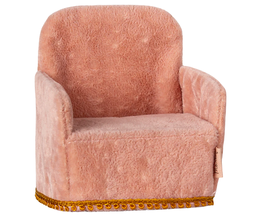 The Maileg Nursery Set's small pink plush chair, featuring a golden fringe trim and a cozy rounded back with armrests, pairs perfectly with the charming Miniature Floor Lamp for a relaxing ambiance.