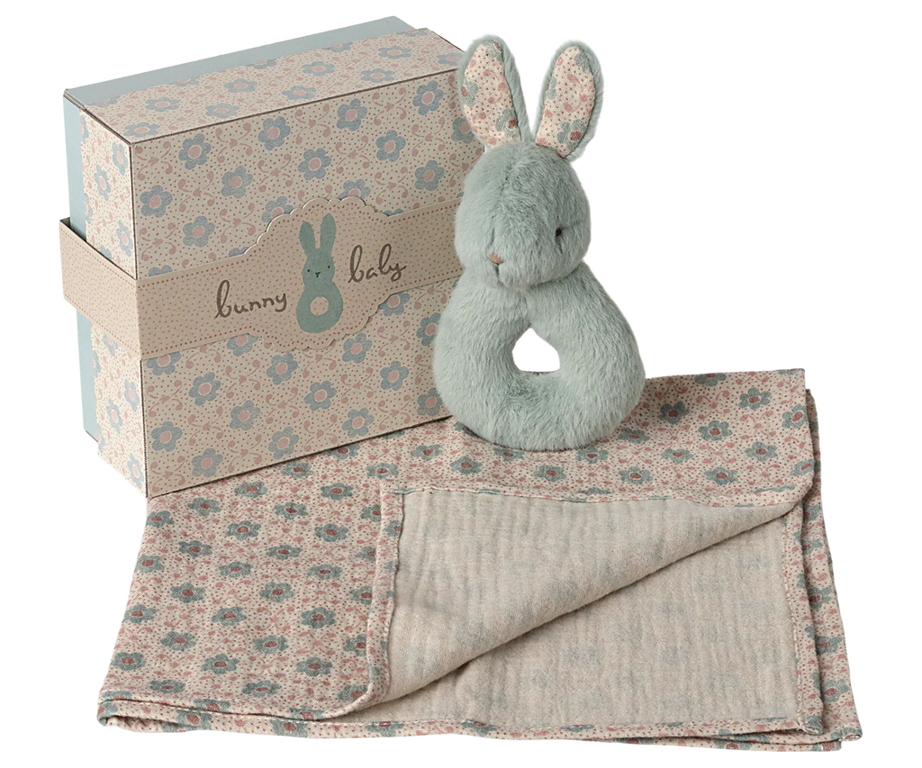 The Maileg Bunny Rattle Set - Mint includes a plush bunny toy, a soft floral-patterned baby blanket, and a bunny rattle in a decorative gift box labeled "bunny baby" with a bunny silhouette. The pastel color scheme enhances its gentle and soothing appearance.