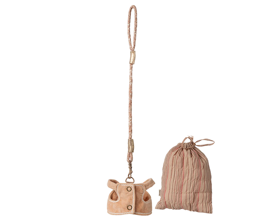The Maileg Sleeping Bunny Supply, Harness features a tan faux-fur bag shaped like a jacket with a beaded polyester strap, alongside a pink striped drawstring pouch, both displayed against a plain background.