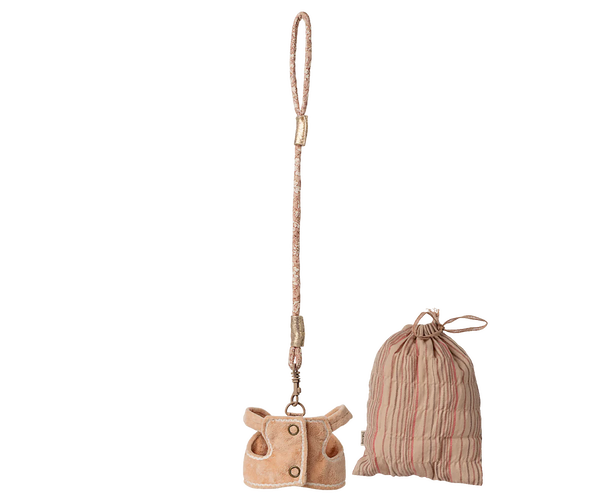 The Maileg Sleeping Bunny Supply, Harness features a tan faux-fur bag shaped like a jacket with a beaded polyester strap, alongside a pink striped drawstring pouch, both displayed against a plain background.
