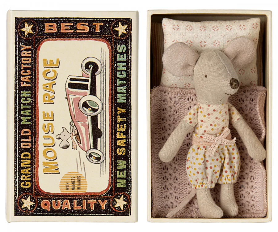 A Maileg Little Sister Mouse in fairy clothes rests in a matchbox bed with the lid reading "Grand Old Match Factory Best Quality Mouse Race New Safety Matches" and showcasing an illustration of a mouse racing a car.