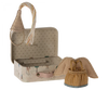 In an open, whimsical polka-dotted suitcase adorned with animals and trees, a Maileg Little Sister Mouse is nestled in its matchbox bed, donning a rope-style party hat. Nearby rests a fabric lion toy sporting a fringed mane.