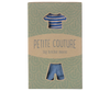 A green package with a shirt and pants cutout reveals blue striped cotton clothing. The text reads "Maileg Knitted Sweater And Pants For Big Brother Mouse," set against a pattern of white arches. Ships in one week.