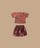A charming Maileg Mom Mouse wears a knitted multicolored top with short sleeves and a shiny burgundy skirt, capturing her playful style against a plain beige background.