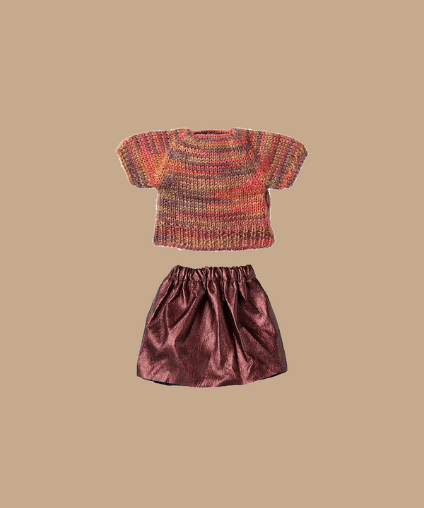 The Maileg Skirt And Knitted Blouse for Mum Mouse, featuring short sleeves and multicolored warm hues, paired with a silky pink metallic skirt, is set against a plain beige backdrop. (Ships in one week).