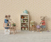 Two mice, dressed in charming outfits, sit at a tiny table with teacups. Nearby are pastries on a shelf, stools, and an egg frying. One mouse sports a sun hat and apron; the other dons a striped shirt with the product "Maileg Denim Dress And Bag For Mum Mouse.