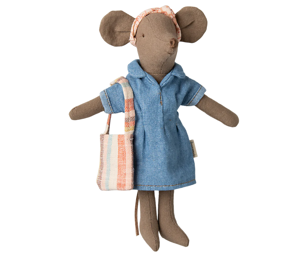The Maileg Denim Dress And Bag For Mum Mouse is a charming stuffed toy mouse in a blue denim dress set with a plaid headband and striped tote bag, made from soft cotton material and elegantly posed against a plain background.
