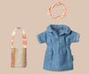 The Maileg Mom Mouse With Extra Outfit - Petite Couture features a small denim dress with short sleeves, perfectly paired with a multicolored striped bag and light pink scrunchie, elegantly displayed on a beige background.