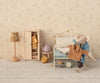 A cozy miniature scene includes a small metal bed with polka dot bedding, a cupboard with mouse clothes, a teapot, pastries, an alarm clock on the floor, and an elephant plush toy wearing Maileg's shirt and striped pants for Dad Mouse. Nearby stands a floral lamp.