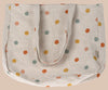 The Maileg Tote Bag With Multi Dots - Small is a beige linen fabric bag decorated with vibrant orange, yellow, red, and green polka dots. It has two sturdy handles and is shown flat against a plain background.