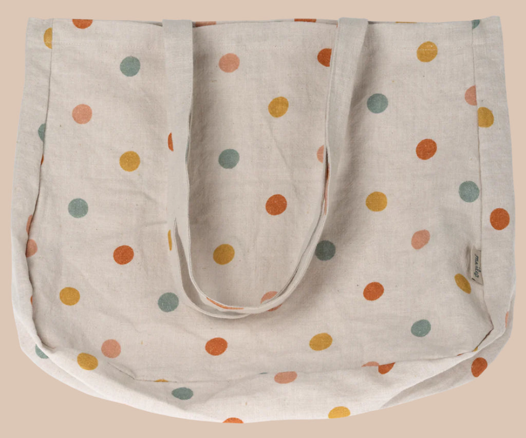 The Maileg Tote Bag With Multi Dots - Small is a beige linen fabric bag decorated with vibrant orange, yellow, red, and green polka dots. It has two sturdy handles and is shown flat against a plain background.