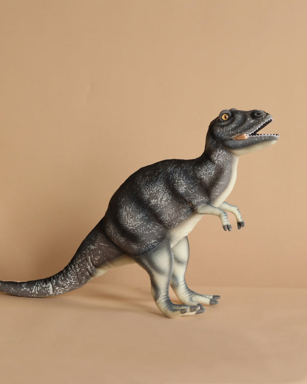 The Albertosaurus Dinosaur Stuffed Animal, with its realistic features, stands against a beige background. It showcases artisan craftsmanship with dark grey stripes and an open mouth displaying sharp teeth.
