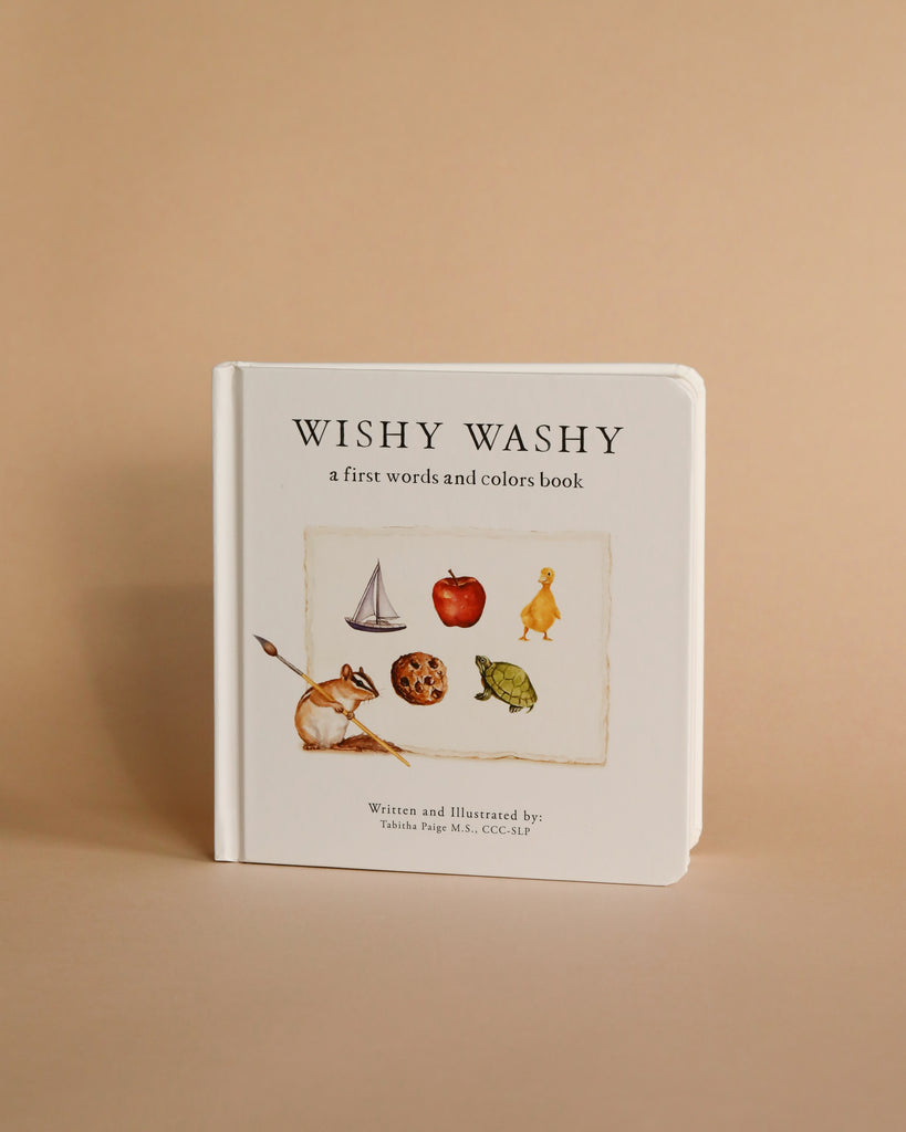Newborn Gift Set" features the delightful "Wishy Washy: A First Words and Colors Book," a charming board book with a chipmunk and yellow duck illustration on a soft beige cover. Ideal for little ones in cozy organic cotton baby rompers.