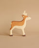 A charming Noah's Ark With Animals Holztiger wooden toy figurine of a deer crafted from solid wood features white accents, a light brown body, and dark brown hooves. Its simplified design with short antlers stands gracefully on a beige background.