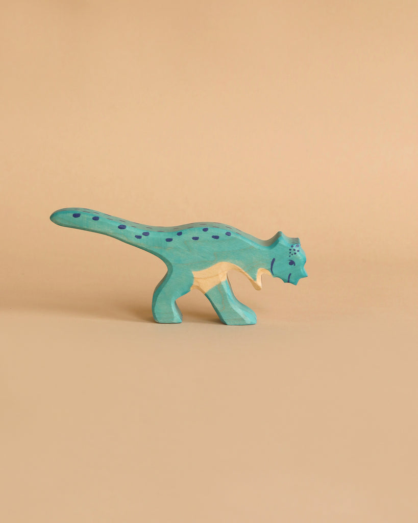 A small, wooden Holztiger Pachycephalosaurus Dinosaur painted light blue with dark blue spots is presented. This handcrafted wood figure stands on two legs with a long tail curving behind it, set against a plain, beige background. Like other HOLZTIGER figures, it exemplifies the quality and charm of being Made in Europe.
