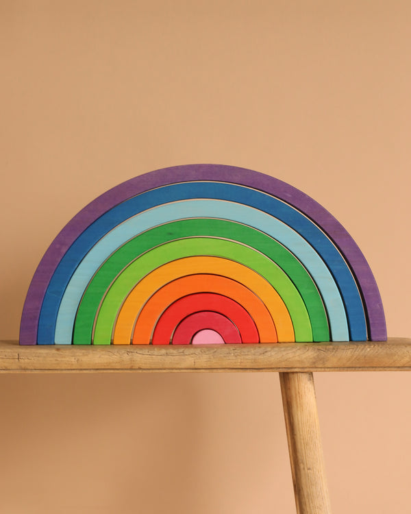 The Bauspiel Rainbow (10 pieces) is a colorful wooden stacking toy with arches, ideal for creative and educational play—perfect as a quality example of Bauspiel wooden toys.