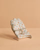The Maileg Sleepy Wakey Baby Mouse In Bouncer features a small, polka-dotted fabric chair with a thin metal frame, perfect for your mouse to relax in soft fabrics—a charming miniature accessory for imaginative play.