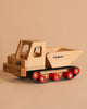 The Fagus Wooden Caterpillar Dumper, made of beech wood with red wheels, black tracks, and "Bergmann" and "fagus" printed on it, is shown against a plain beige background.